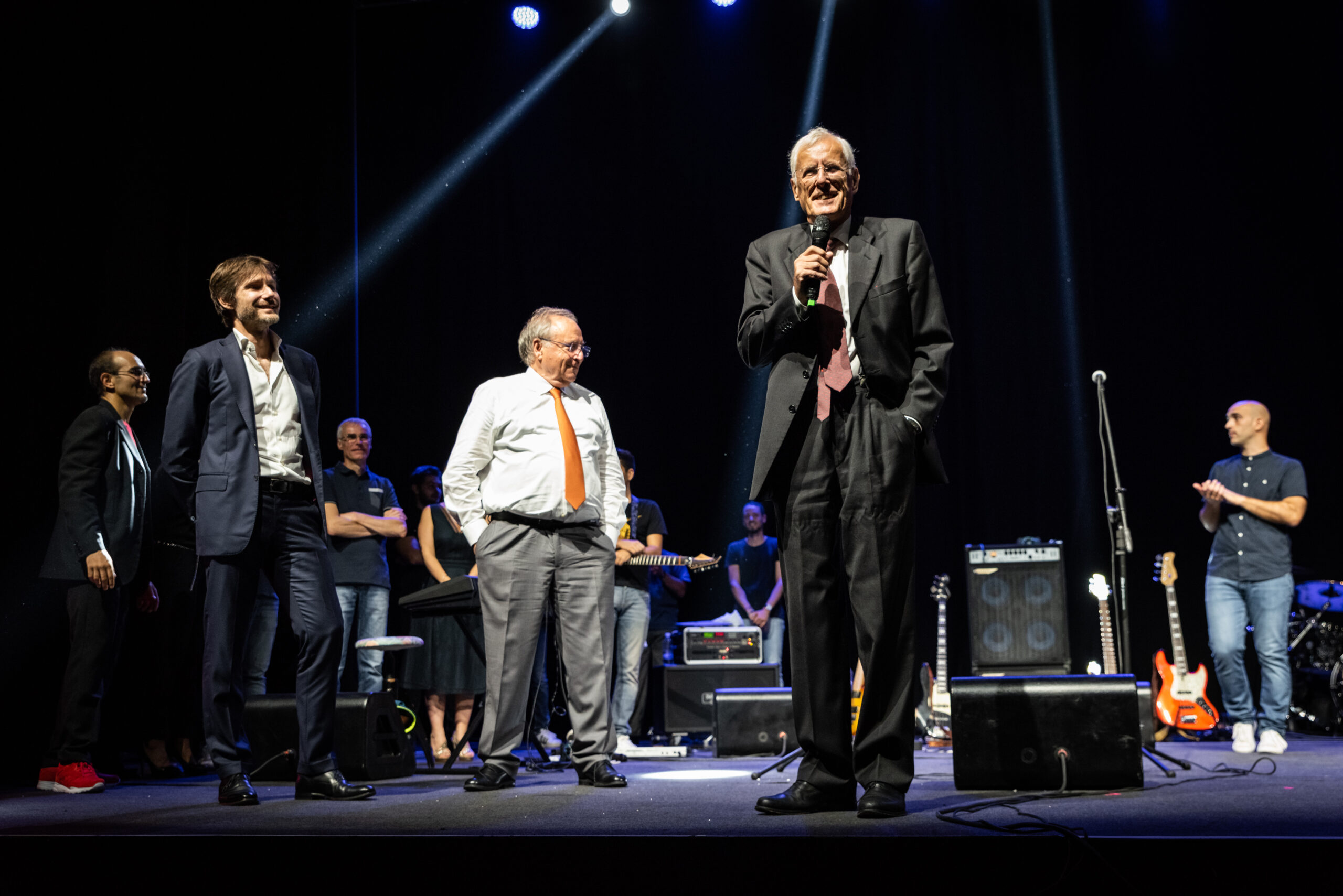 Amministratore delegato con microfono sul palco insieme agli ospiti di un evento aziendale, servizio fotografico business events a Padova