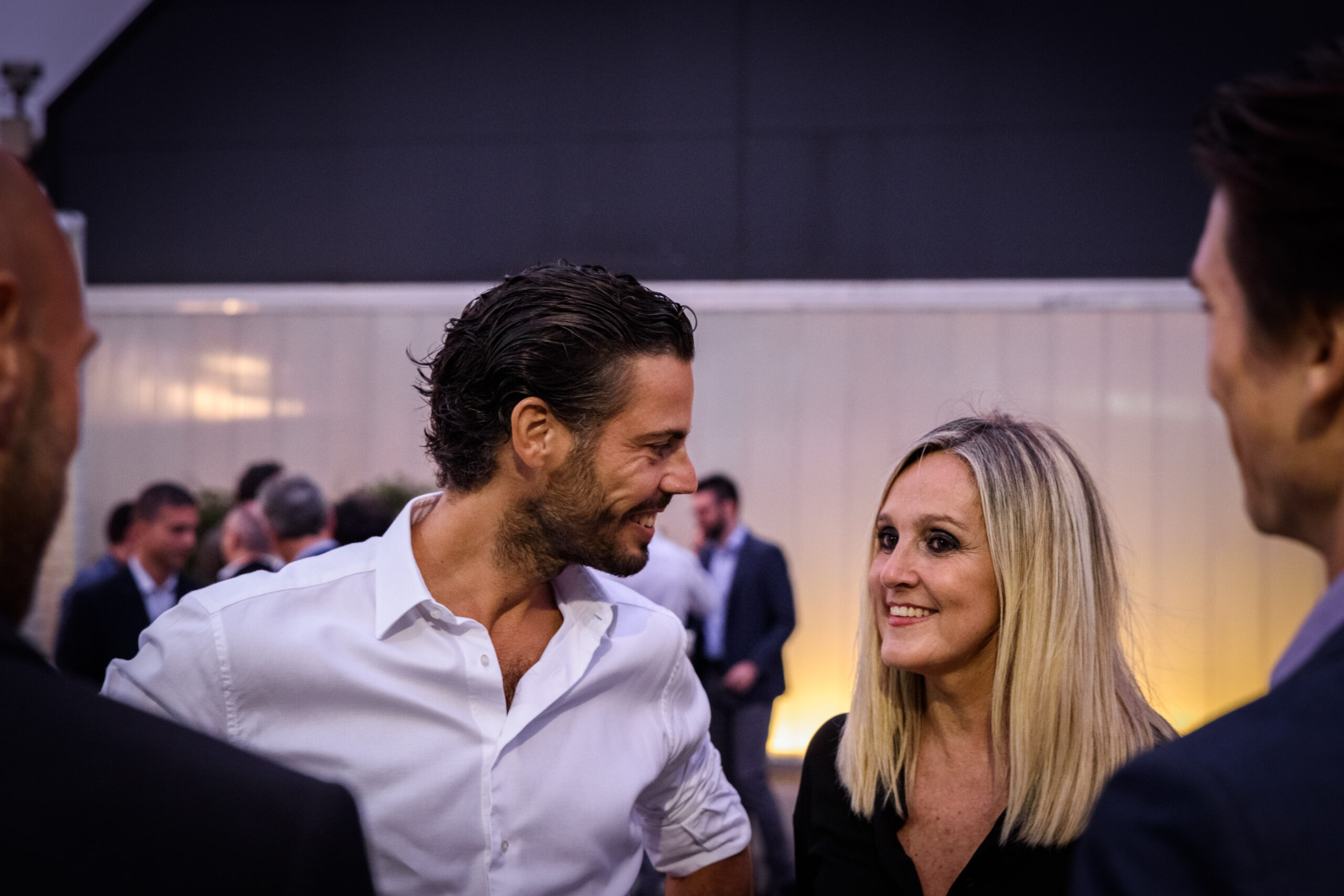 Ospiti conversano durante un evento aziendale serale, servizio fotografico business events a Padova