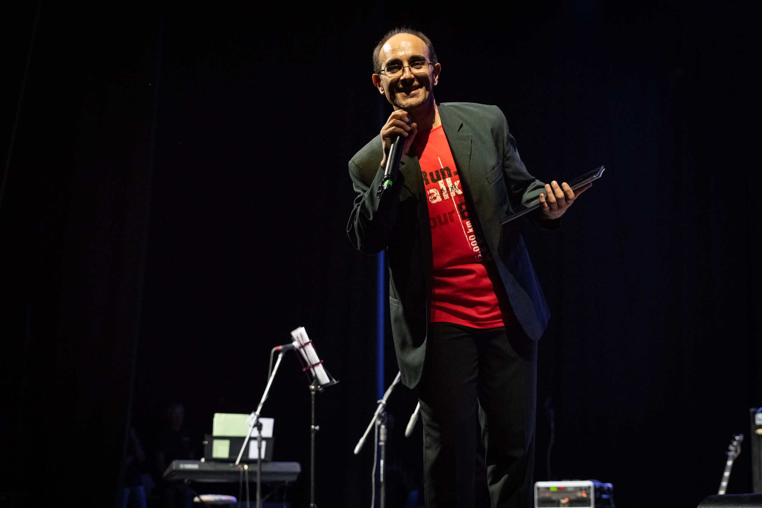 Presentatore con microfono sul palco durante un evento aziendale, servizio fotografico business events a Padova