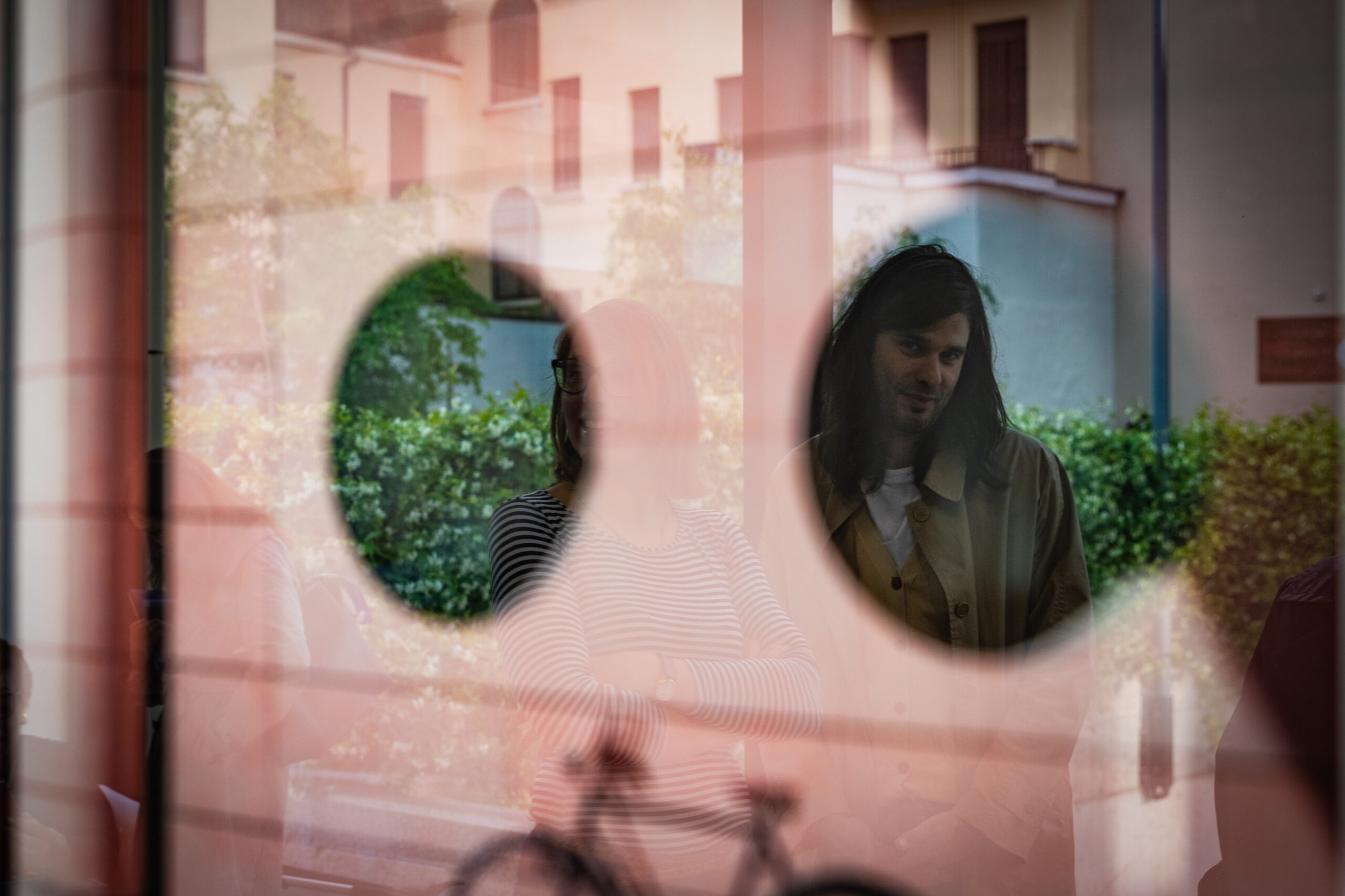 Partecipanti ritratti attraverso un riflesso durante un evento aziendale, servizio fotografico business events a Padova