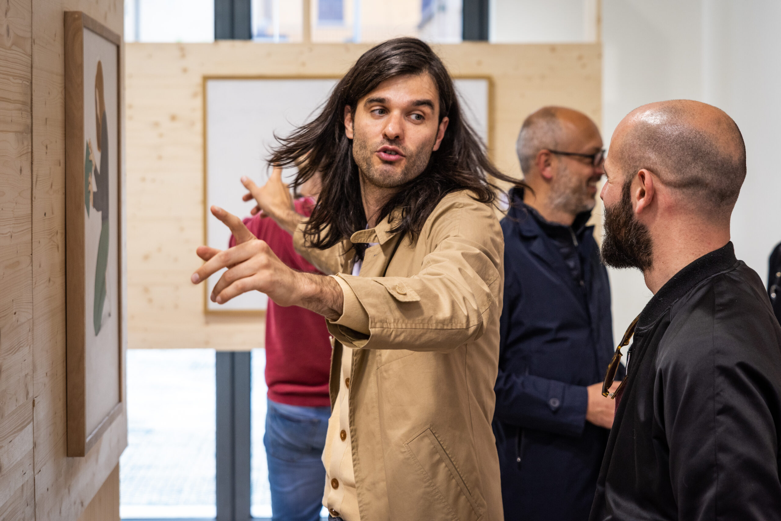 Ospiti conversano davanti alle opere durante un evento aziendale, servizio fotografico business events a Padova