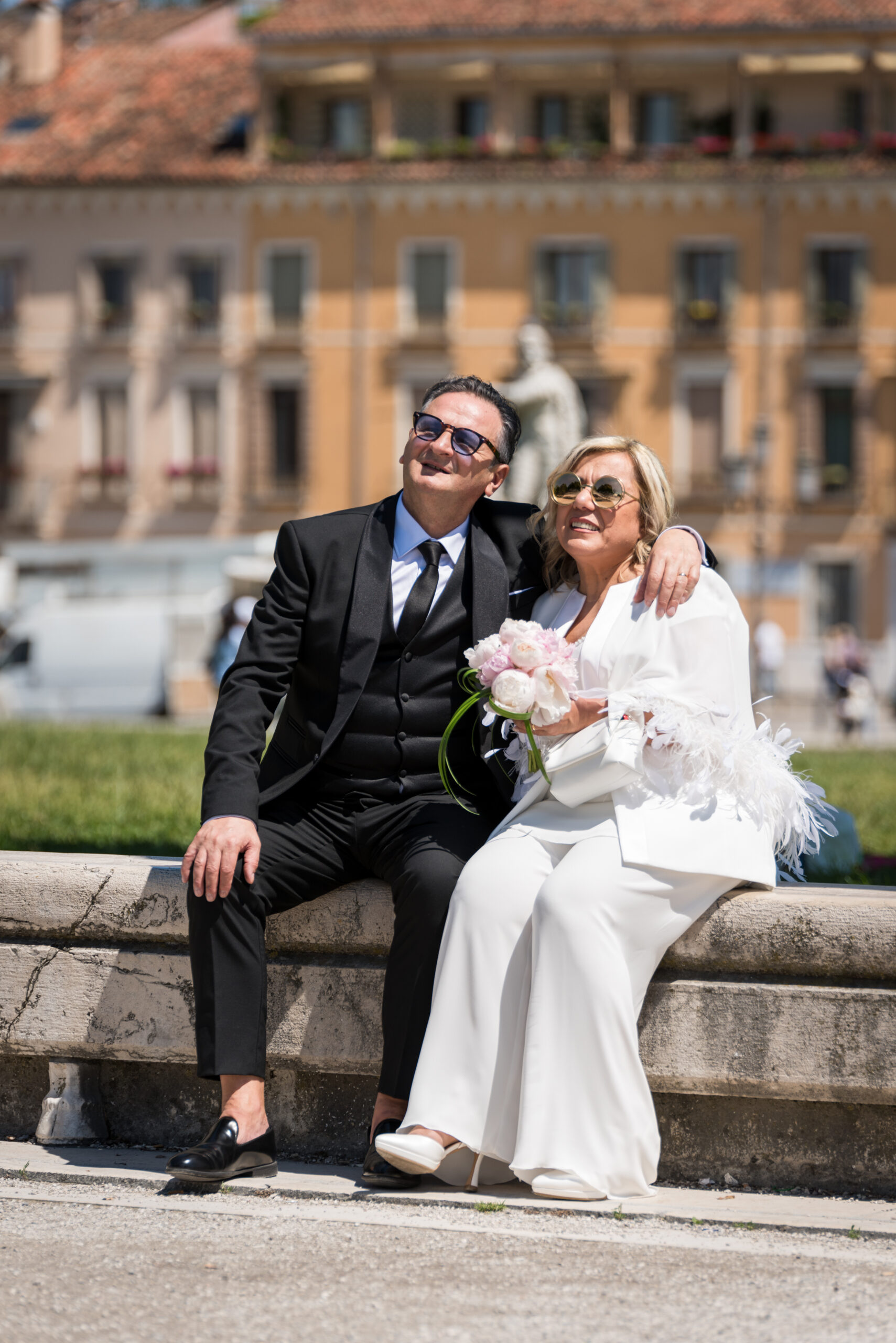 Ritratto degli sposi seduti in Prato della Valle nel giorno del matrimonio, progetto Storie da condividere a Padova