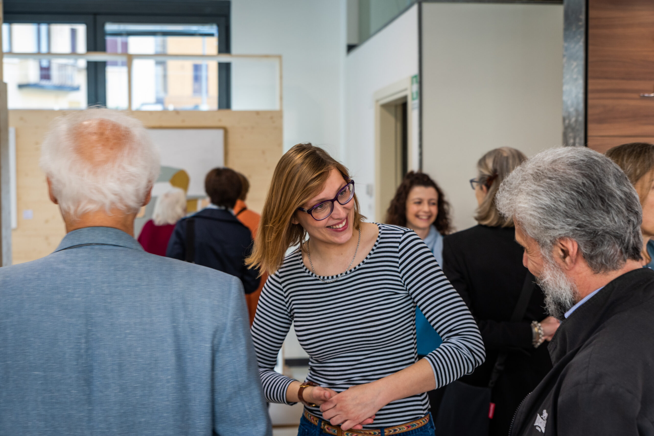 Partecipanti e autrice conversano durante una mostra in uno spazio espositivo, servizio fotografico business events a Padova