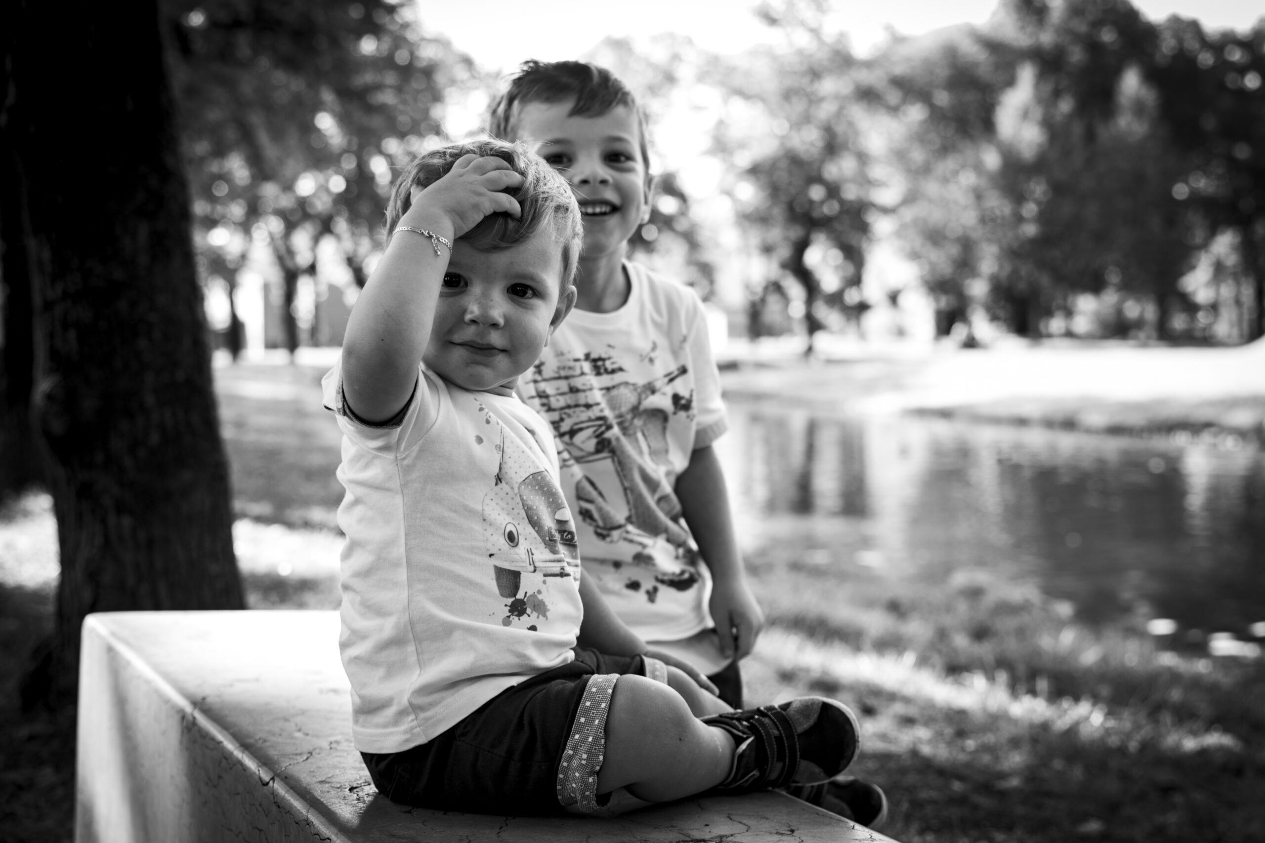 Due bambini sorridenti in un parco, ritratto in bianco e nero del progetto Storie di famiglia a Padova