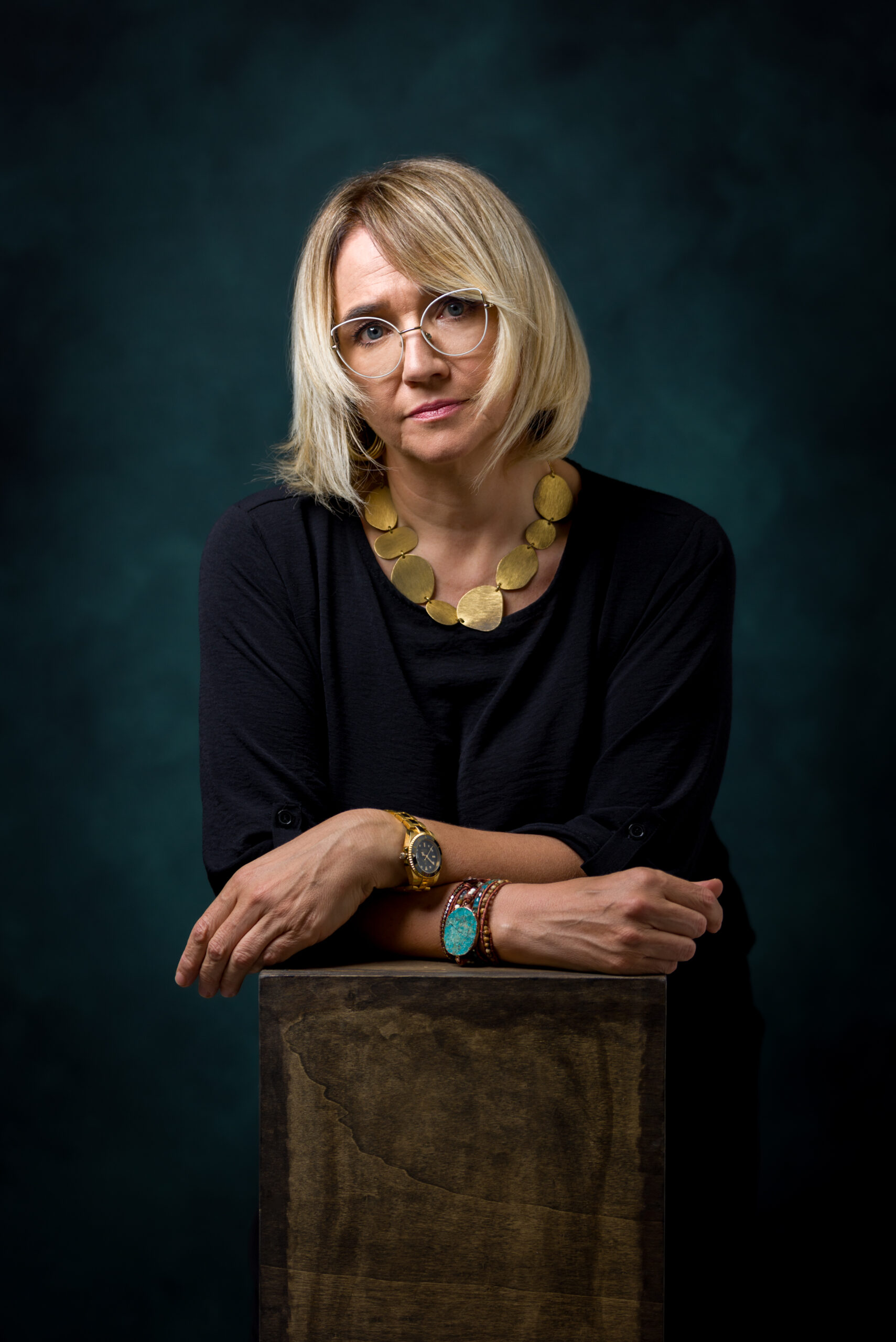 Ritratto in studio di donna con occhiali e collana dorata, progetto Storie di sé a Padova