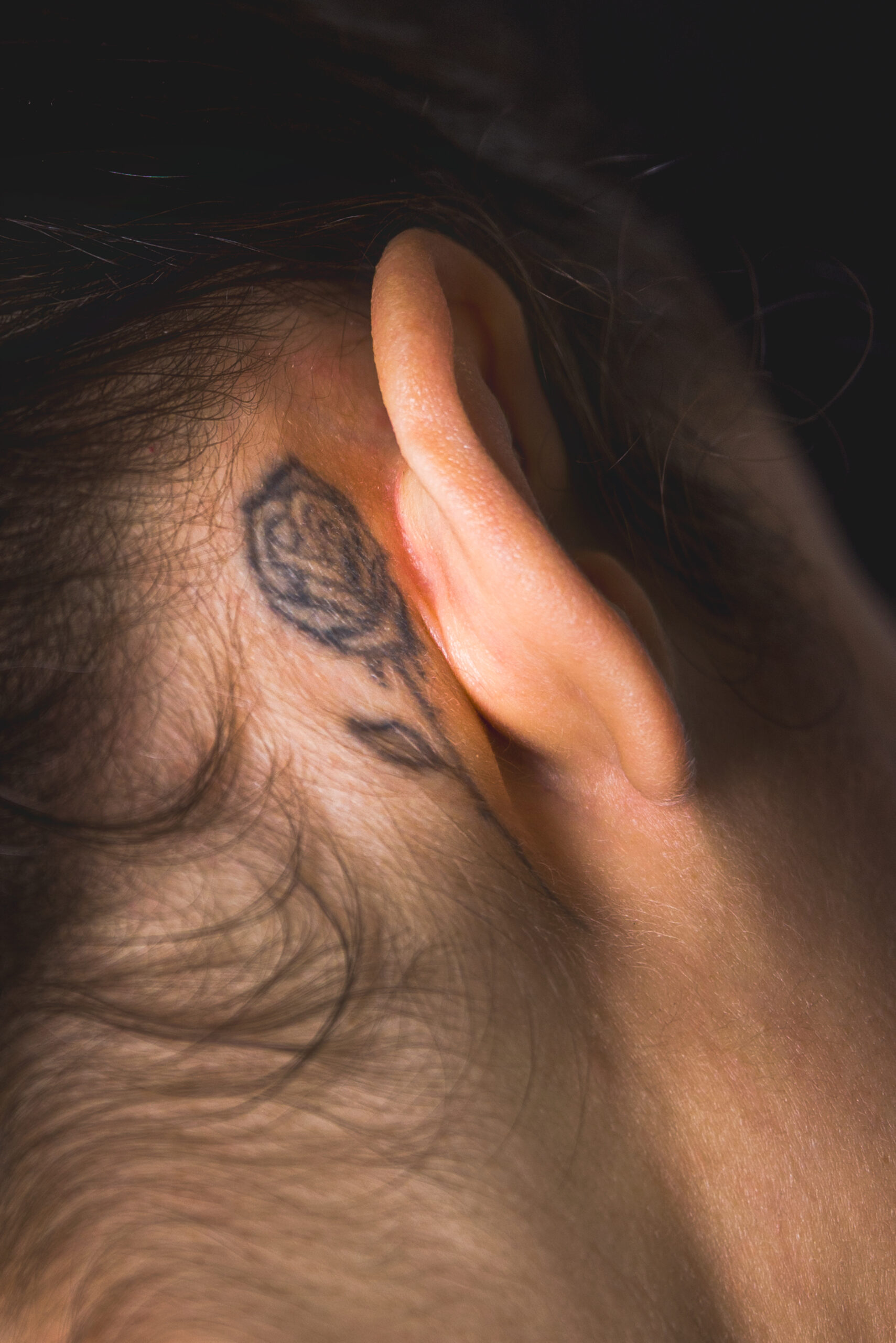 Primo piano dell’orecchio con tatuaggio in un ritratto femminile, servizio About Me a Padova