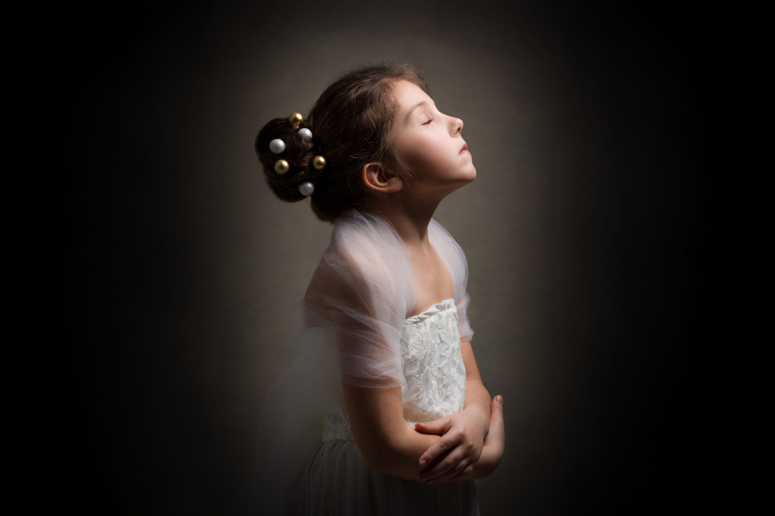 Ritratto fine art di bambina con abito bianco e acconciatura decorata a Padova