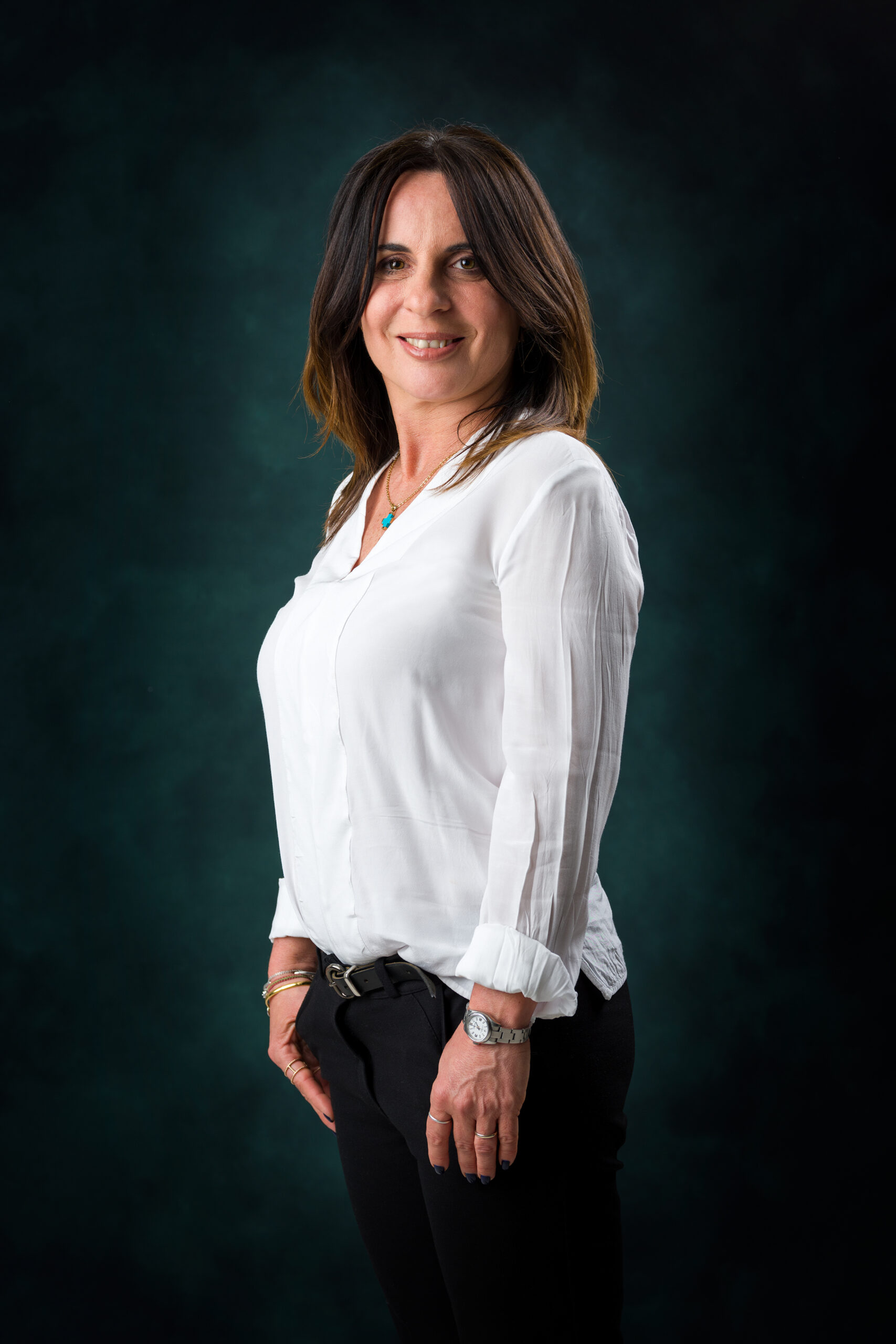 Ritratto professionale di donna con camicia bianca su sfondo verde scuro a Padova