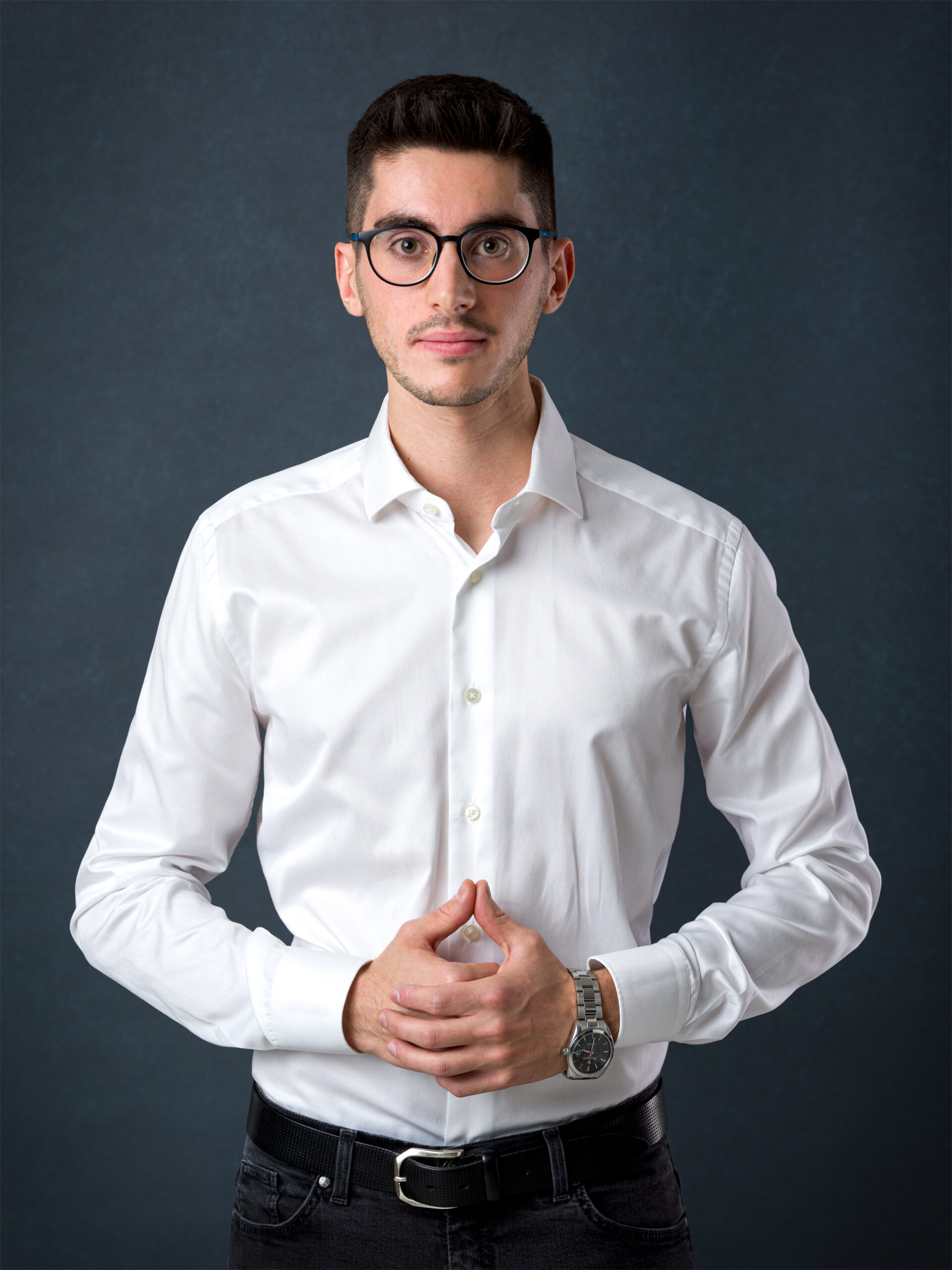 Ritratto professionale di uomo con occhiali e camicia bianca su sfondo blu a Padova